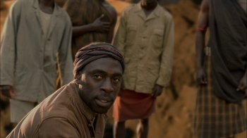 Movie still from “Dominion: Prequel to the Exorcist” (2005), directed by Paul Schrader – A group of men standing next to each other; Close Up shot, Over the shoulder angle