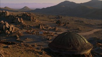 Movie still from “Dominion: Prequel to the Exorcist” (2005), directed by Paul Schrader – An image of a desert scene with mountains in the background; Extreme Wide shot, High angle