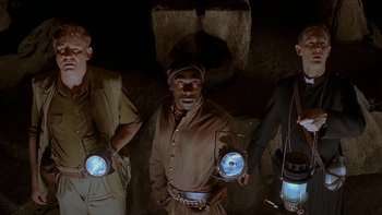 Movie still from “Dominion: Prequel to the Exorcist” (2005), directed by Paul Schrader – A group of men standing next to each other holding lanterns; Medium shot, Low angle