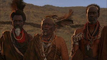 Movie still from “Dominion: Prequel to the Exorcist” (2005), directed by Paul Schrader – A group of people standing next to each other on top of a hill; Close Up shot, Low angle