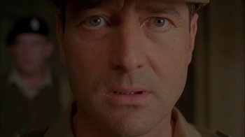 Movie still from “Dominion: Prequel to the Exorcist” (2005), directed by Paul Schrader – A man's face with a hat on his head; Close Up shot, Low angle