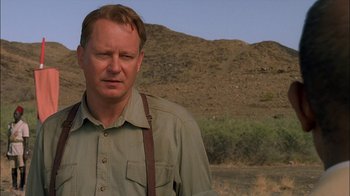 Movie still from “Dominion: Prequel to the Exorcist” (2005), directed by Paul Schrader – A person standing in a field near a hill; Close Up shot, Low angle