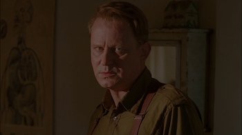 Movie still from “Dominion: Prequel to the Exorcist” (2005), directed by Paul Schrader – A person wearing a shirt and tie; Close Up shot, Over the shoulder angle
