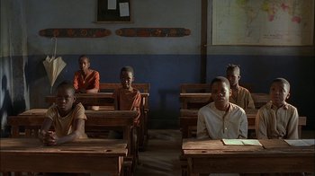 Movie still from “Dominion: Prequel to the Exorcist” (2005), directed by Paul Schrader – A group of children sitting at desks in a classroom; Wide shot, High angle