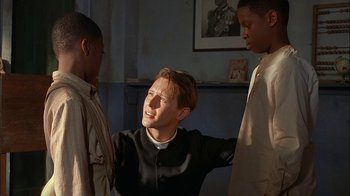 Movie still from “Dominion: Prequel to the Exorcist” (2005), directed by Paul Schrader – A group of young men standing next to each other in a room; Medium shot, Over the shoulder angle