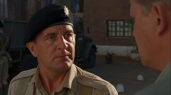 Movie still from “Dominion: Prequel to the Exorcist” (2005), directed by Paul Schrader – A man in a military uniform looking at the camera; Close Up shot, Over the shoulder angle