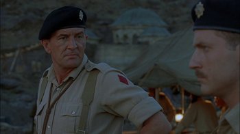 Movie still from “Dominion: Prequel to the Exorcist” (2005), directed by Paul Schrader – A man in a military uniform standing in front of an umbrella; Close Up shot, Low angle