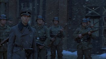 Movie still from “Dominion: Prequel to the Exorcist” (2005), directed by Paul Schrader – A group of men standing next to each other; Medium shot, Low angle