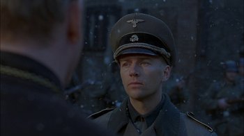 Movie still from “Dominion: Prequel to the Exorcist” (2005), directed by Paul Schrader – A man in a military uniform is standing in the snow; Close Up shot, Over the shoulder angle