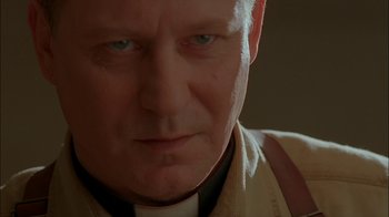 Movie still from “Dominion: Prequel to the Exorcist” (2005), directed by Paul Schrader – A man's face in a dark room; Close Up shot, Low angle