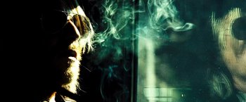 Movie still from “Domino” (2005), directed by Tony Scott – A person is smoking a cigarette in front of a window; Extreme Close Up shot, Low angle