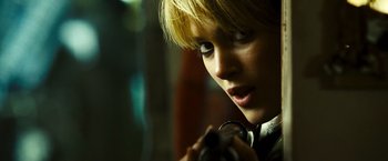Movie still from “Domino” (2005), directed by Tony Scott – A person holding a camera; Close Up shot, Low angle