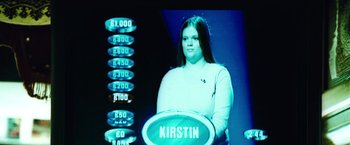 Movie still from “Domino” (2005), directed by Tony Scott – A woman standing in front of a screen with the name kirstin on it; Extreme Close Up shot, Low angle