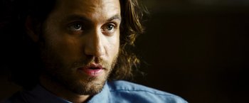 Movie still from “Domino” (2005), directed by Tony Scott – A person with long hair and a beard; Close Up shot, Over the shoulder angle