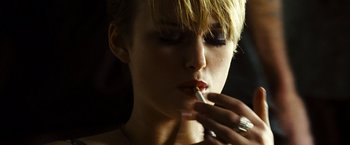 Movie still from “Domino” (2005), directed by Tony Scott – A woman is putting lipstick on her lips; Close Up shot, Low angle