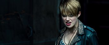 Movie still from “Domino” (2005), directed by Tony Scott – A person with short blonde hair; Close Up shot, Over the shoulder angle