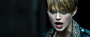 Movie still from “Domino” (2005), directed by Tony Scott – A person with short blonde hair; Close Up shot, Over the shoulder angle