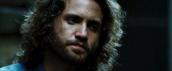 Movie still from “Domino” (2005), directed by Tony Scott – A person with long hair and a beard; Close Up shot, Low angle