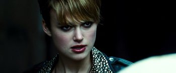 Movie still from “Domino” (2005), directed by Tony Scott – A person with short hair; Close Up shot, Over the shoulder angle