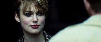 Movie still from “Domino” (2005), directed by Tony Scott – A person with short blonde hair; Close Up shot, Over the shoulder angle