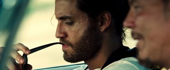 Movie still from “Domino” (2005), directed by Tony Scott – A person with a beard; Close Up shot, Over the shoulder angle