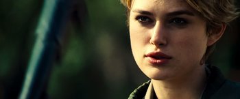 Movie still from “Domino” (2005), directed by Tony Scott – A young woman's face in a forest setting; Close Up shot, Over the shoulder angle