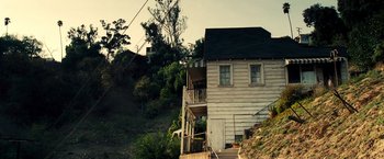 Movie still from “Domino” (2005), directed by Tony Scott – A house sitting on top of a hill with stairs; Extreme Wide shot, Low angle