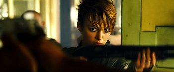 Movie still from “Domino” (2005), directed by Tony Scott – A person holding a camera; Close Up shot, Over the shoulder angle