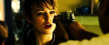 Movie still from “Domino” (2005), directed by Tony Scott – A woman holding a camera up to her face; Close Up shot, Over the shoulder angle
