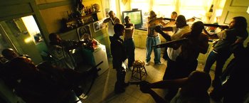 Movie still from “Domino” (2005), directed by Tony Scott – A group of young people standing in a kitchen; Wide shot, High angle