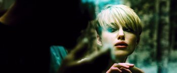 Movie still from “Domino” (2005), directed by Tony Scott – A woman with short blonde hair smoking a cigarette; Close Up shot, Over the shoulder angle