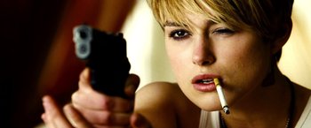 Movie still from “Domino” (2005), directed by Tony Scott – A person holding a gun and a cigarette; Close Up shot, Low angle