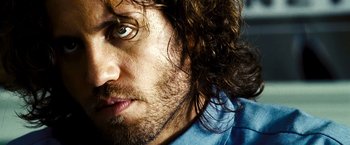 Movie still from “Domino” (2005), directed by Tony Scott – A person with a beard; Close Up shot, Low angle