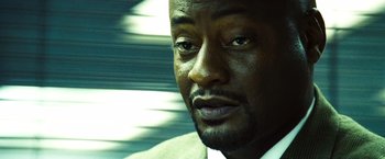 Movie still from “Domino” (2005), directed by Tony Scott – A man's face in front of a blurry background; Close Up shot, Low angle