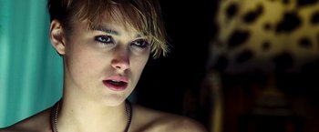 Movie still from “Domino” (2005), directed by Tony Scott – A person with short blonde hair; Close Up shot, Over the shoulder angle