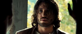 Movie still from “Domino” (2005), directed by Tony Scott – A person with long hair and a beard; Close Up shot, Low angle