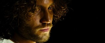 Movie still from “Domino” (2005), directed by Tony Scott – A person with a beard; Close Up shot, Low angle