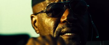 Movie still from “Domino” (2005), directed by Tony Scott – A man's face wearing sunglasses; Extreme Close Up shot, Low angle