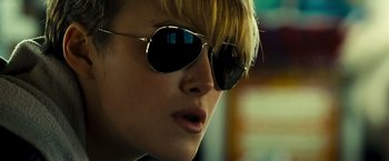 Movie still from “Domino” (2005), directed by Tony Scott – A person wearing a pair of sunglasses; Close Up shot, Low angle