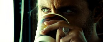 Movie still from “Domino” (2005), directed by Tony Scott – A person drinking a cup of coffee; Extreme Close Up shot, Over the shoulder angle