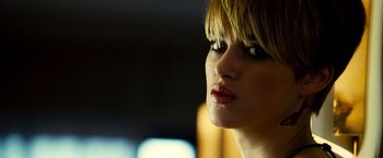 Movie still from “Domino” (2005), directed by Tony Scott – A woman's face in a dark room; Close Up shot, Over the shoulder angle