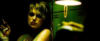 Movie still from “Domino” (2005), directed by Tony Scott – A woman standing next to a green locker; Close Up shot, Low angle