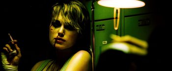 Movie still from “Domino” (2005), directed by Tony Scott – A woman sitting on a train with her head turned to the side; Close Up shot, Low angle