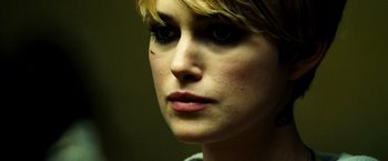 Movie still from “Domino” (2005), directed by Tony Scott – A woman's face in a dark room; Close Up shot, Over the shoulder angle