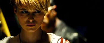 Movie still from “Domino” (2005), directed by Tony Scott – A person with short hair; Close Up shot, Over the shoulder angle