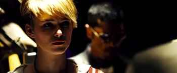 Movie still from “Domino” (2005), directed by Tony Scott – A man and a woman standing next to each other; Close Up shot, Over the shoulder angle