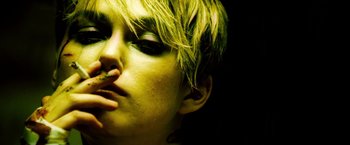 Movie still from “Domino” (2005), directed by Tony Scott – A person's face with green hair; Close Up shot, Low angle