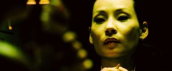 Movie still from “Domino” (2005), directed by Tony Scott – A woman's face in a dark room; Close Up shot, Low angle