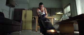 Movie still from “Don Jon” (2013), directed by Joseph Gordon-Levitt – A man in white shirt and black pants using a vacuum; Medium shot, Low angle
