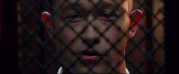 Movie still from “Don Jon” (2013), directed by Joseph Gordon-Levitt – A person behind a chain link fence; Extreme Close Up shot, Overhead angle